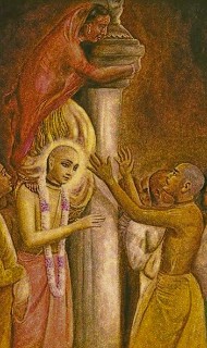 Traditional devotional painting of a robed saint with a garland beside a tall pillar, surrounded by seekers in active debate, reflecting themes of impersonalism and the impulse to judge sadhus.
