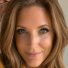 Close-up portrait of a woman with blue eyes and light-brown hair, softly lit on a neutral background, illustrating a blog on healing after abuse, divorce, trauma, rebuilding trust, and wisdom.