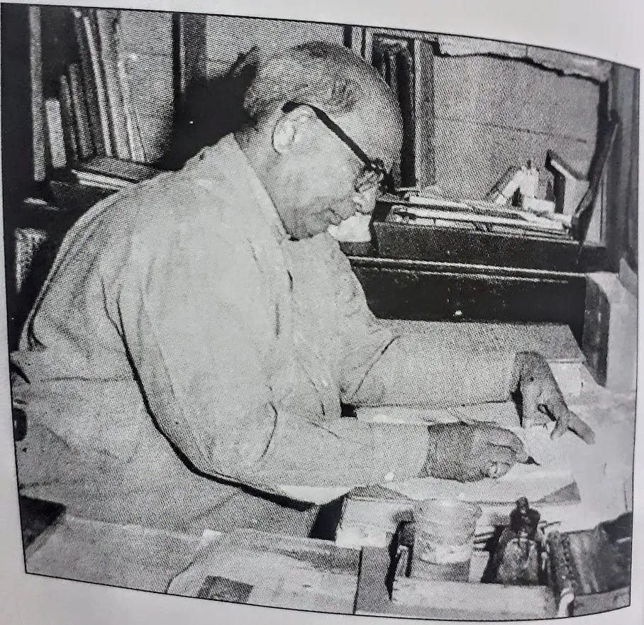 Archival black-and-white photo of a bespectacled elder writing at a cluttered desk, papers and books stacked around. Scholarly workspace illustrating themes of patience, study, and lived experience.
