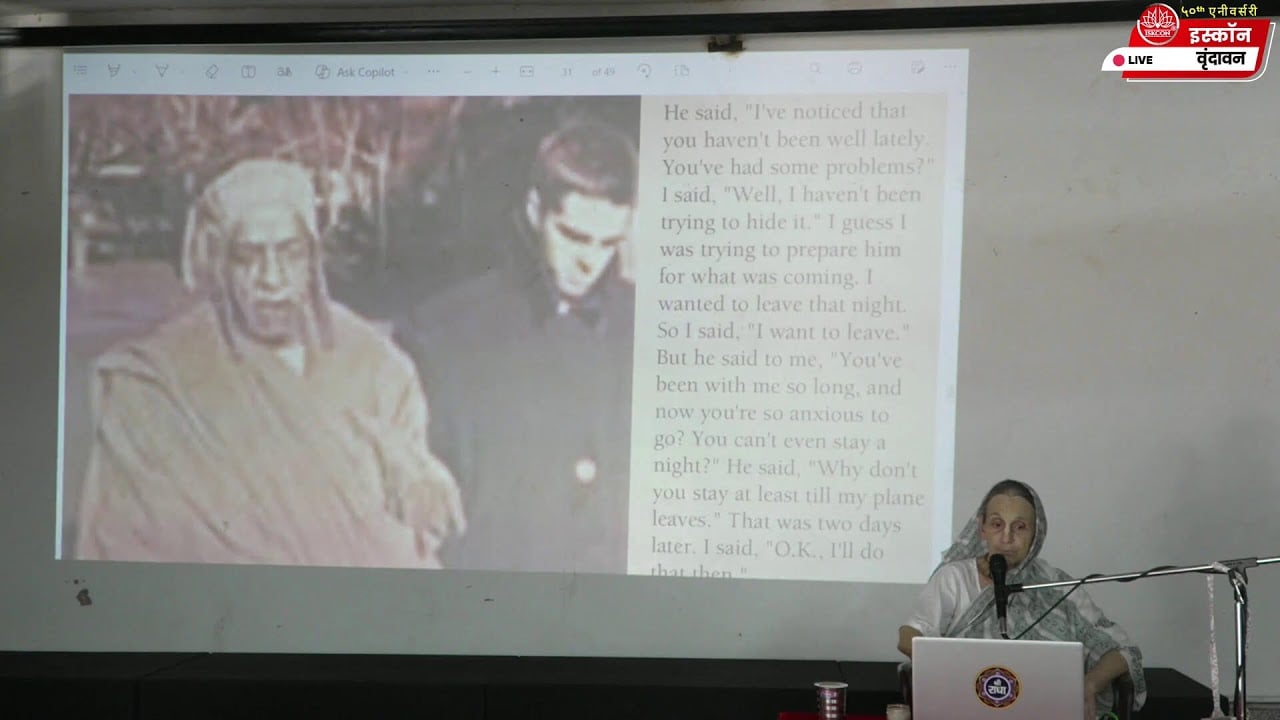 A speaker presents a slide with a vintage photo and English text during a live ISKCON Vrindavan session on Srila Prabhupada Lilamrita, in a classroom setting; accessible, testing category.