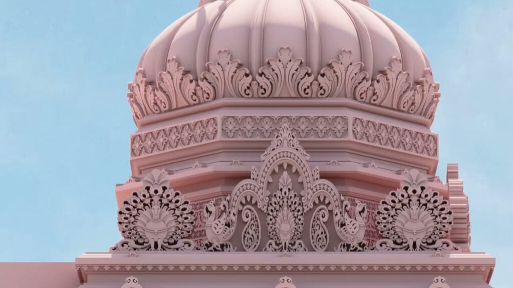 Close-up of a proposed temple dome from the ISKCON Los Angeles master plan, showing pink stonelike surfaces, dense floral scrollwork, and twin peacock motifs under a clear sky; rendering.