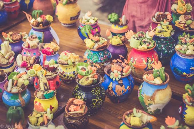 Colorful painted earthen pots filled with Chida Dahi prasada, fruit, sweets, and festival offerings for the Panihati Chipped Rice Festival.