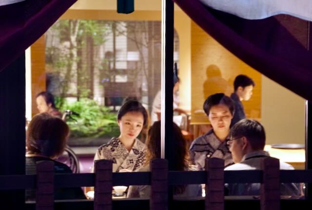 People gather for an evening meal inside a Kyoto machiya, evoking dharma tradition, guru yoga, and finding a spiritual mentor during Gion Matsuri.