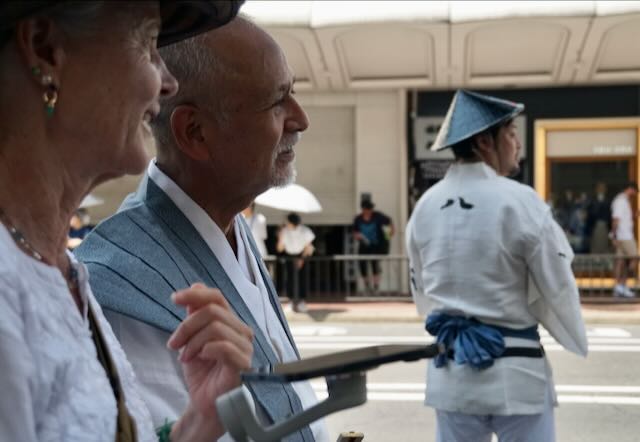 Two Dharma practitioners watch a Gion Matsuri Festival attendant in Kyoto, reflecting guru yoga, Awakening, and finding a spiritual mentor.