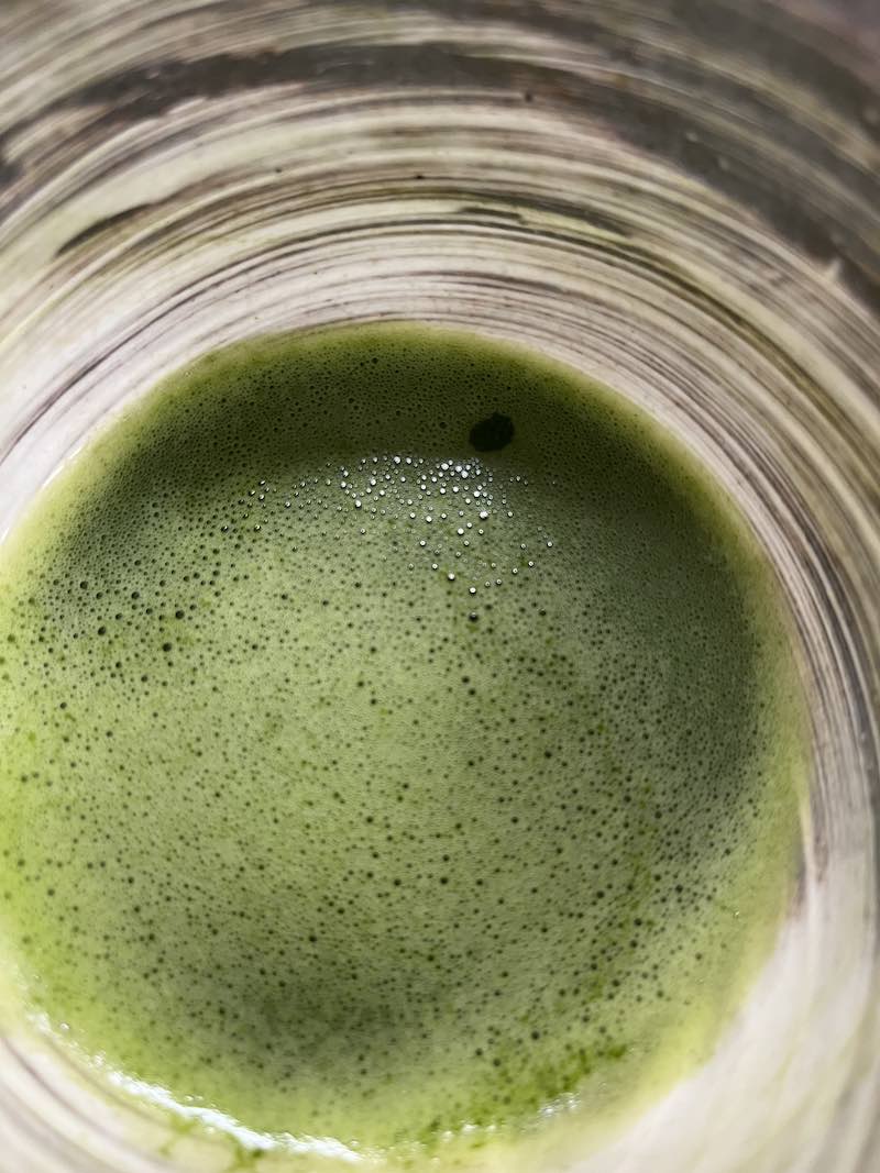 Close-up of frothy green matcha tea in a cup, evoking Kyoto tea practice, guru yoga, Dharma tradition, Awakening, and finding a spiritual mentor.