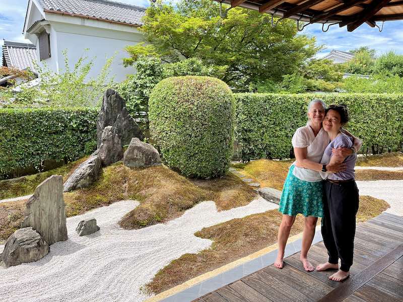 Catherine Sensei and Cara embrace beside a Kyoto machiya Zen garden, reflecting guru yoga, Dharma tradition, and finding a spiritual mentor.