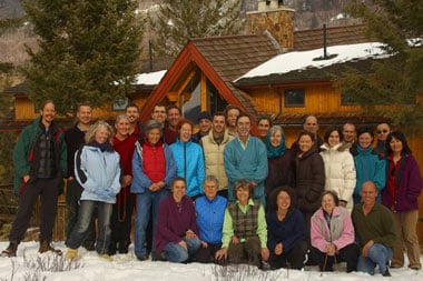 Group of Dharma retreat participants posing in snow outside a wooden lodge, evoking Integral Evolution, community, and 21st-Century Awakening.