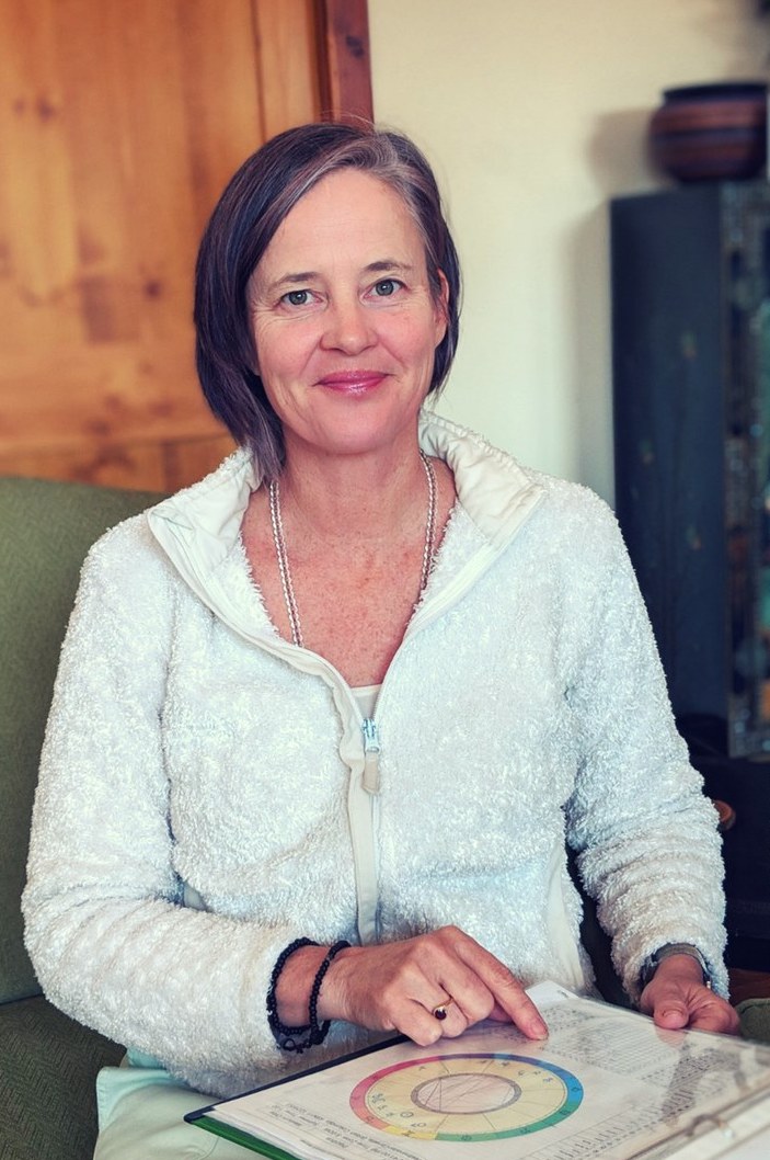 Catherine Pawasarat Sensei seated with an AstroDharma chart, reflecting Saturn, mastery, discipline, and Dharma awakening teachings.
