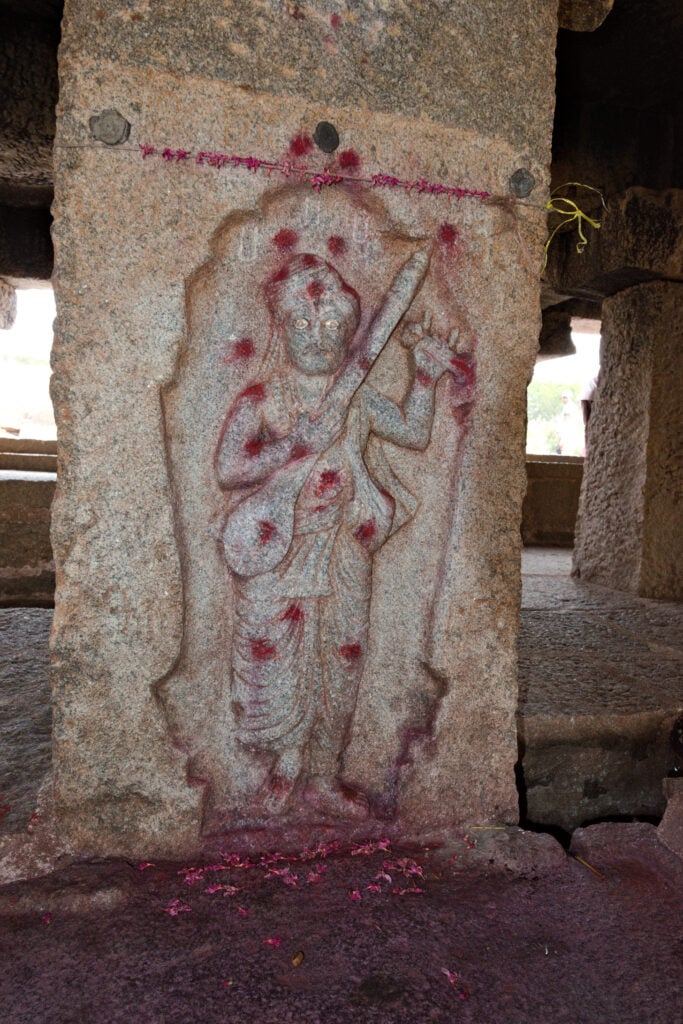Stone relief of Purandaradasa holding a tambura inside Purandaradasa Mantapa at Hampi, Karnataka, linked to Haridāsas and Vijayanagara.