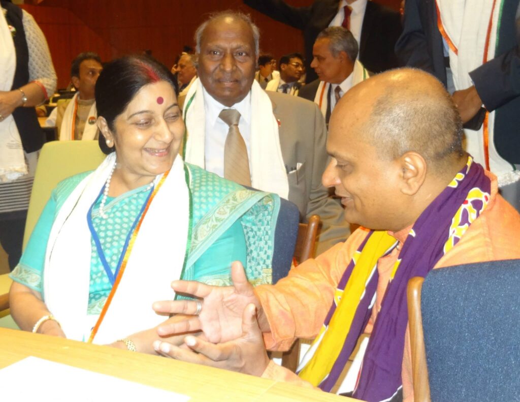 Sushma Swaraj speaks with Yogi Dileep Kumar at an international gathering, reflecting Kerala Yoga conversations tied to the United Nations Yoga Day.