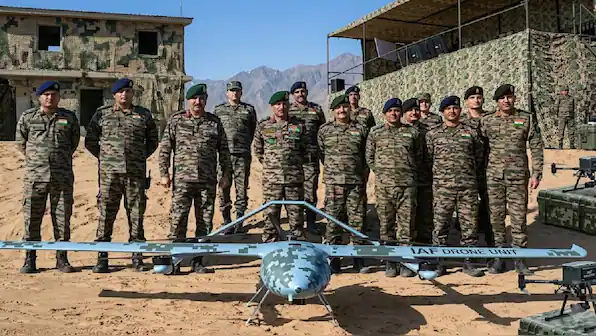 Bharat defence personnel in camouflage stand with a fixed-wing military drone at a training site, highlighting Indian Army drone warfare readiness.