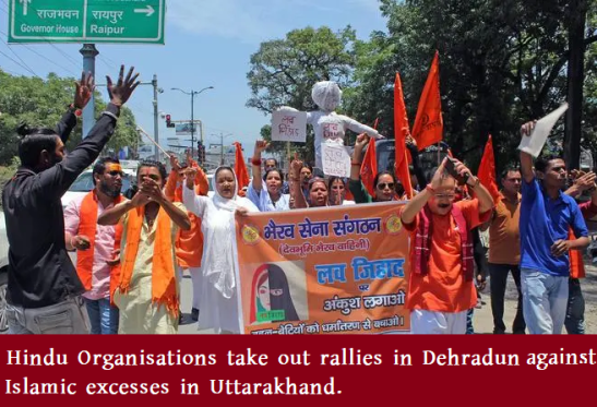 Hindu Existence image of a Dehradun street rally with saffron flags and banners during an anti-halal, anti-jihad Hindutva campaign in Uttarakhand.