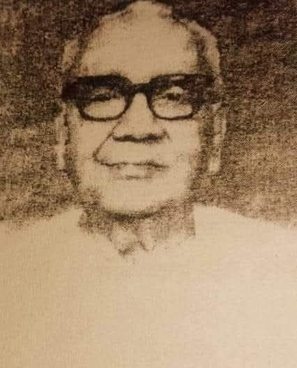 Sepia archival portrait of Advocate Monoranjan Dhar, an elderly Bangladesh history figure wearing dark glasses and light clothing.