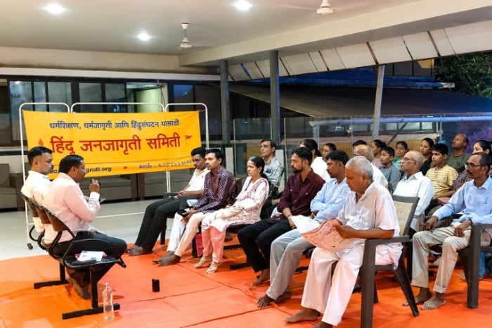 Community meeting with Hindu Janajagruti Samiti banner as residents discuss concerns affecting Hindu families in Bisur, Sangli.