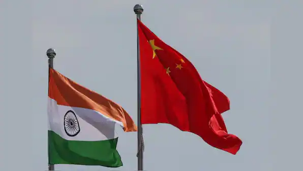 Indian and Chinese national flags fly side by side, symbolizing Bharat-China geopolitics, strategic caution, and debates over de-Americanising foreign policy.