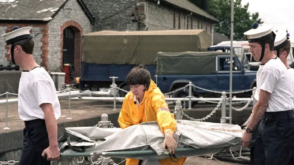 Rescue personnel carry a covered stretcher at a harbor during Air India Flight 182 recovery, evoking Canada, Khalistani terror, Bharat and World terrorism.