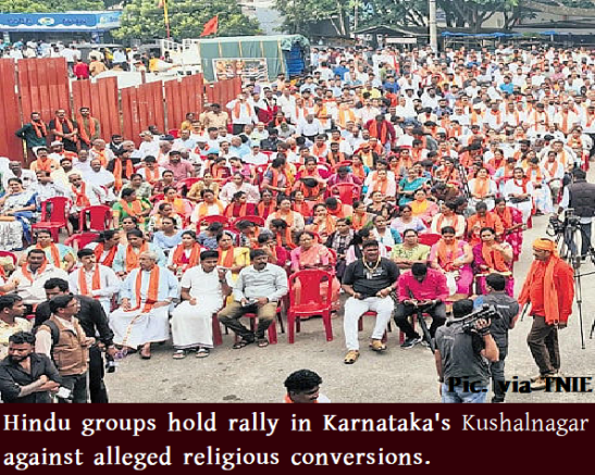 Crowd of Hindu rally attendees seated in red chairs in Kushalnagar, Karnataka, at a protest about alleged religious conversions and Christian Conversion concerns.
