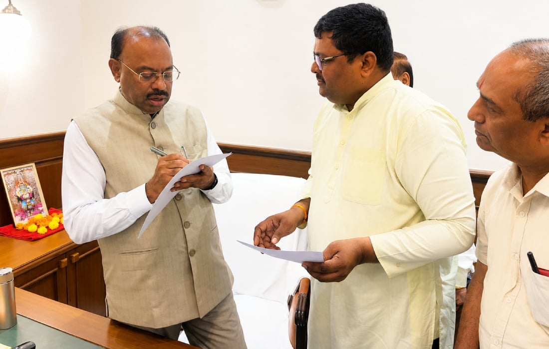 Maharashtra official reviews and signs documents during a memorandum submission linked to the Shri Tuljabhavani Mandir 4,121-acre land scam inquiry.