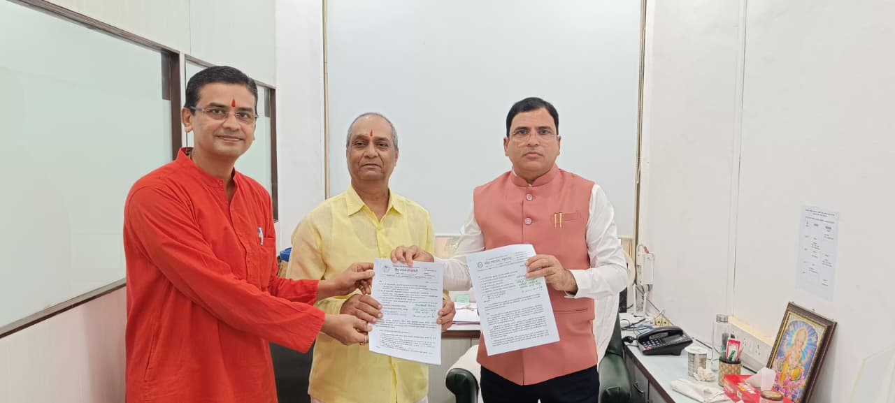 Three men in an office hold official documents related to the Solapur probe into alleged unauthorised church use and municipal employee misconduct.