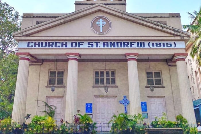 Front view of Church of St. Andrew, 1815, with columns, cross symbols and garden fencing, illustrating a report on the Solapur church probe.