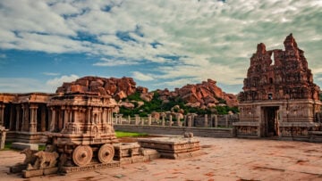 Vijayanagara stone chariot and ornate temple ruins under a cloudy sky, evoking South Indian sacred travel from Tiruvannamalai to Sri Rangam.
