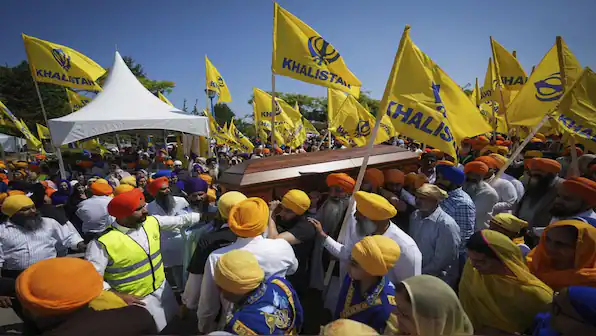 Crowd at a Sikh gathering carrying yellow Khalistan flags, illustrating Punjab separatism concerns tied to terrorism and Bharat security debates.
