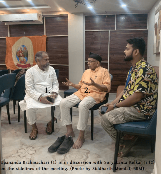 Upananda Brahmachari and Suryakanta Kelkar Ji seated in discussion at a Bharat Raksha Manch West Bengal meeting on Hindu Existence and infiltration issues.