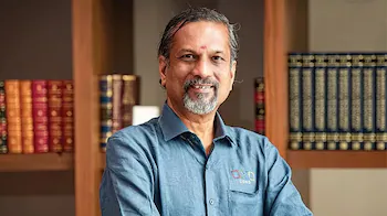 Zoho founder Sridhar Vembu stands with folded arms before bookshelves, illustrating Bharat media debate on Modi, Amit Shah, BJP and Ramachandra Guha.