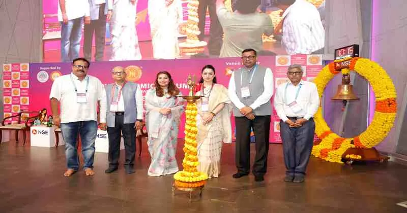 Dignitaries at a World Hindu Economic Forum event in Mumbai stand beside a ceremonial lamp during a women entrepreneurship felicitation ceremony.