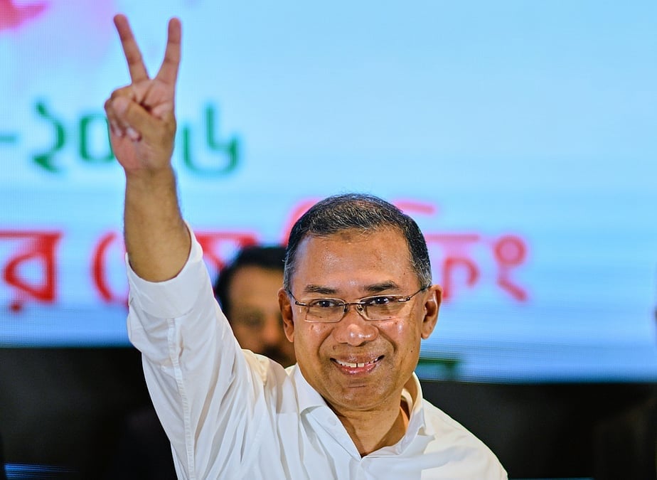 Bangladesh BNP leader in a white shirt raises a victory sign at a public event, illustrating Anti-Hindu concerns and Persecution of Hindus debate.