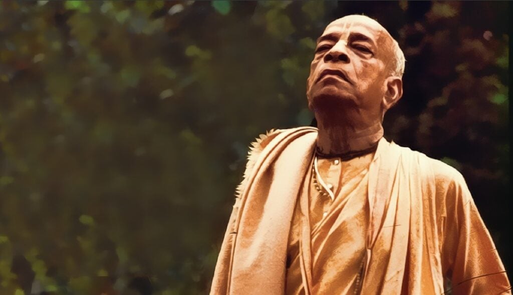 Elderly Vaishnava spiritual teacher in saffron robes standing outdoors, reflecting self-confidence, humility, Krishna devotion, and bhakti wisdom.