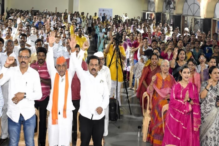 Large indoor Hindu Janajagruti Samiti gathering with attendees raising hands, linked to demands over Sharad Pawar's Vaikunthgaman remarks.
