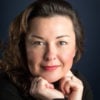 Portrait of Dr. Sarah Davies resting her chin on her hands, representing a Blog post about toxic workplace stress, self-doubt, and emotional safety.
