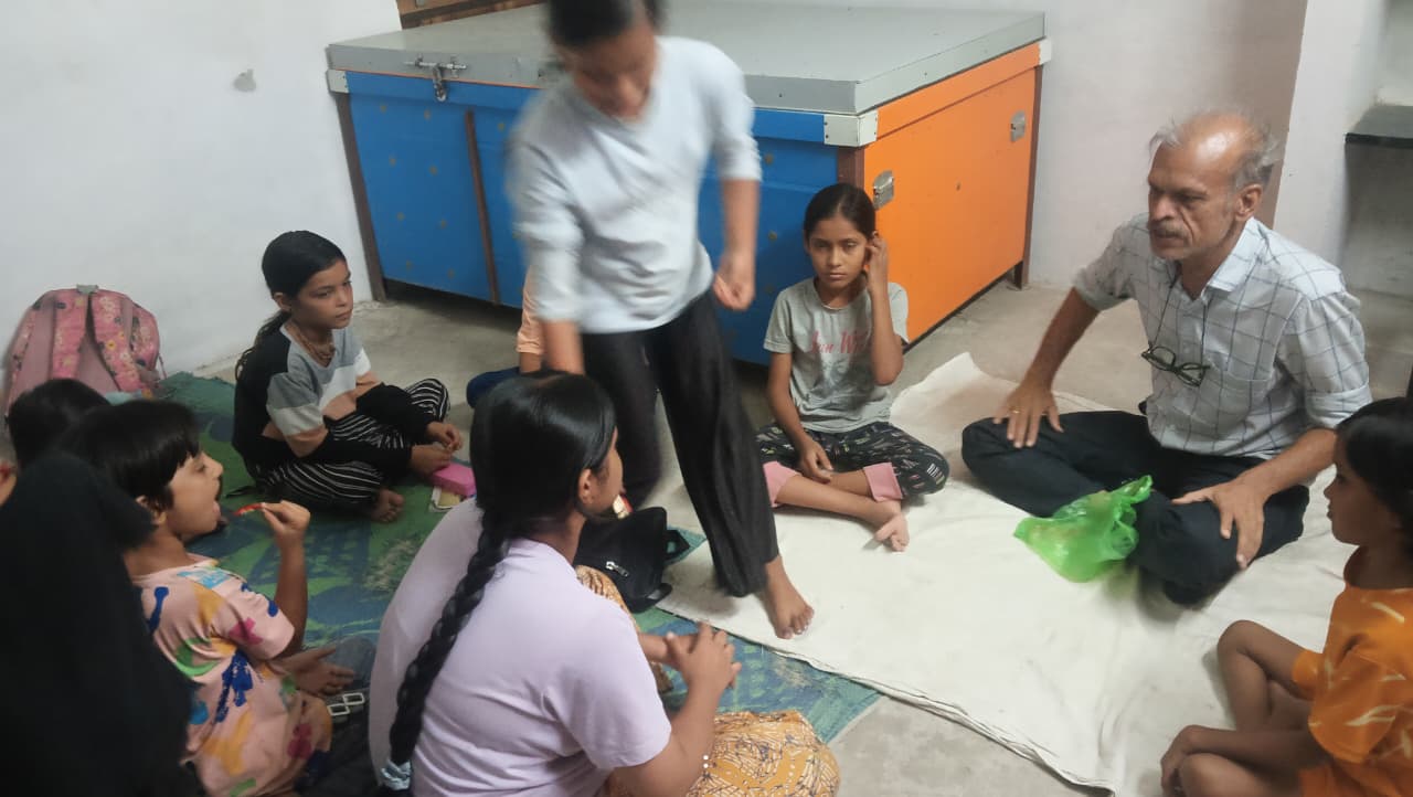 सेवा भारती संस्कार केंद्र में फर्श पर बैठे बच्चे और शिक्षक, हिन्दू साम्राज्य दिनोत्सव पर चर्चा सुनते हुए, Hindi Bharat समाचार संदर्भ