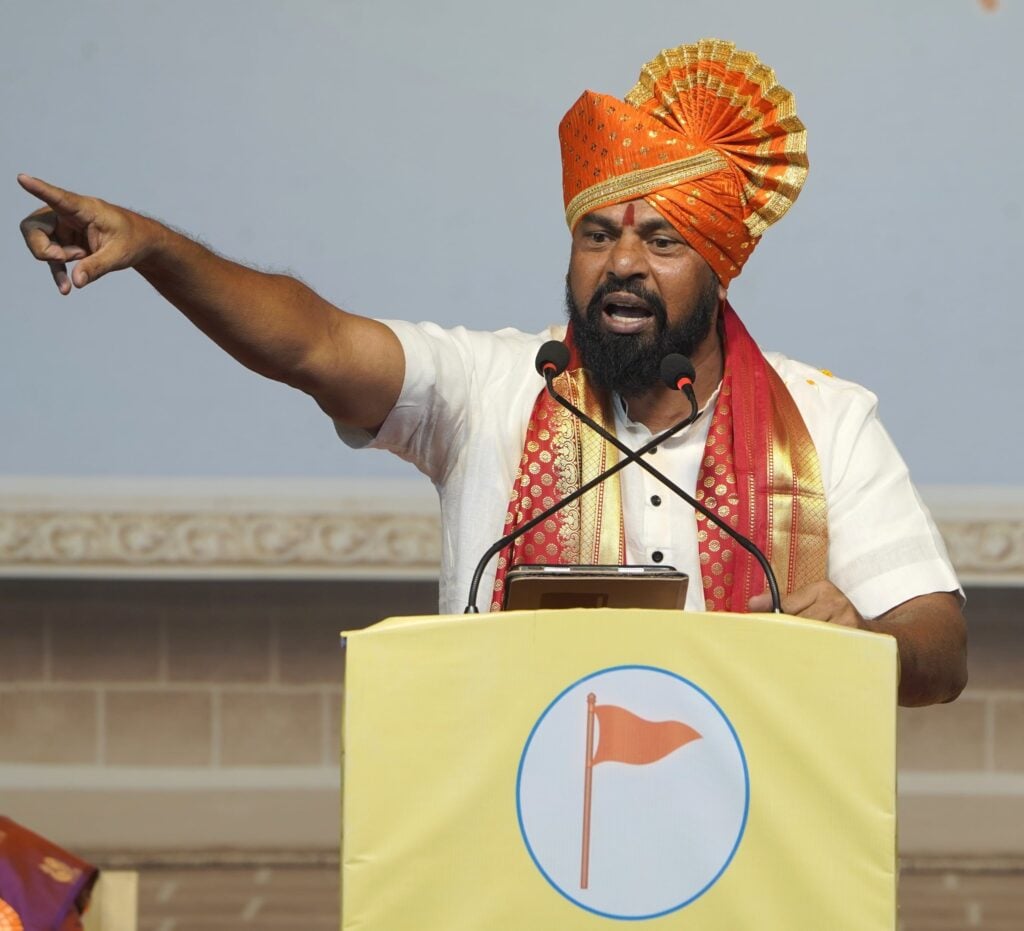 MLA T. Raja Singh speaks at a podium in traditional saffron headgear, pointing during a public address linked to the Telangana Court acquittal case.