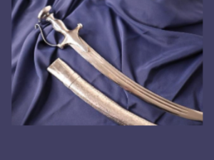 Traditional Sikh sword and scabbard resting on blue draped cloth, symbolizing courage, sacrifice, and the legacy of Bhai Mani Singh.