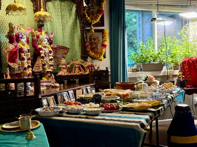 A lavish anniversary feast arranged before the flower-garlanded Sri Sri Nitai Nimai Chandra deities on an ornate home altar in Seattle.