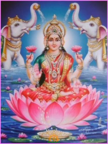 Goddess Varalakshmi seated on a pink lotus, holding lotus flowers as two white elephants flank her, for Shravan Maas in the Marathi Calendar.