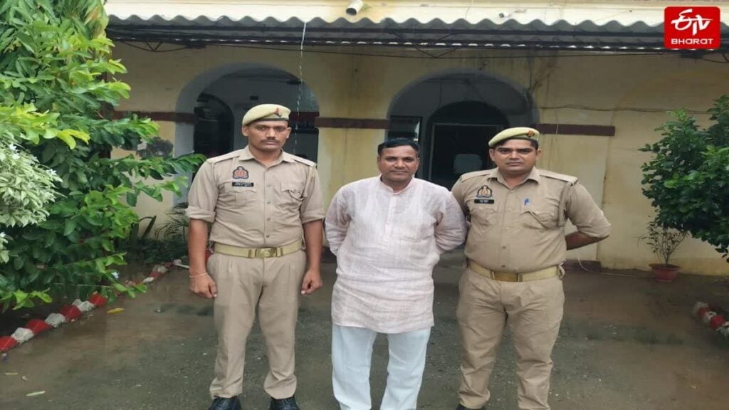 Two uniformed Uttar Pradesh police officers stand beside a man in white outside a station in Bareilly, linked to an alleged religious conversion case.