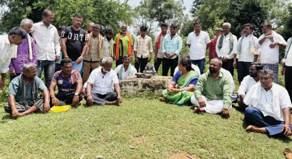 Villagers gather around a damaged shrine site in Amblikoppa, Dharwad, Karnataka, after the reported vandalism of the Beeralingeshwara murti.
