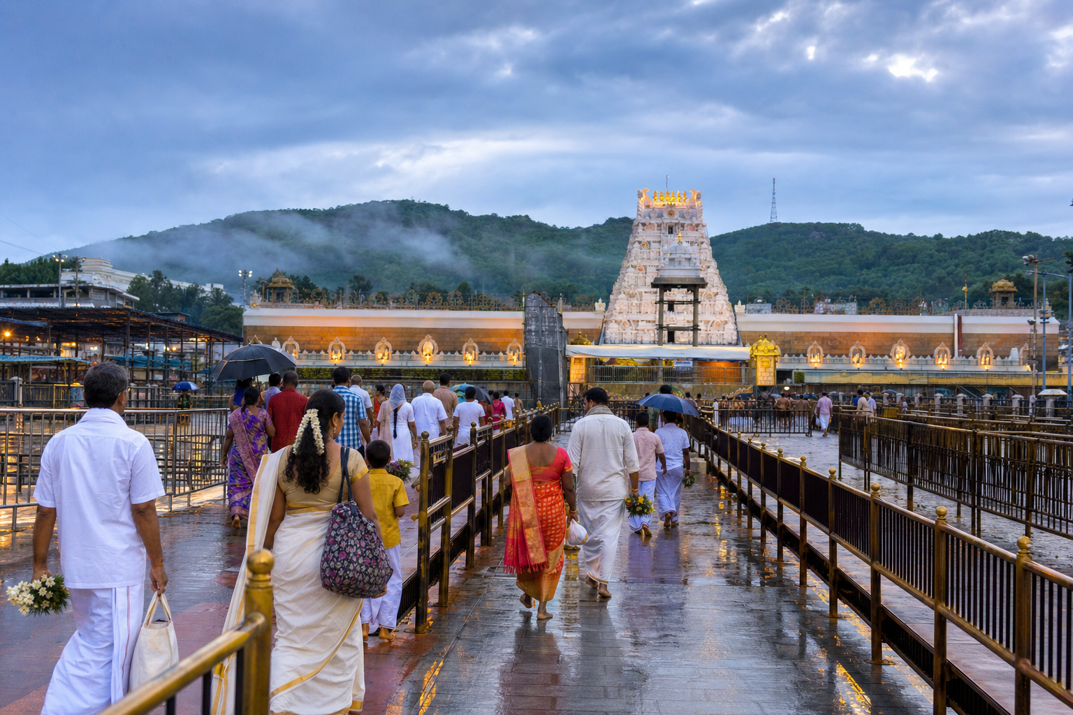 Pilgrims carrying flower offerings approach a South Indian temple on Tirumala hill beneath cloudy June skies.