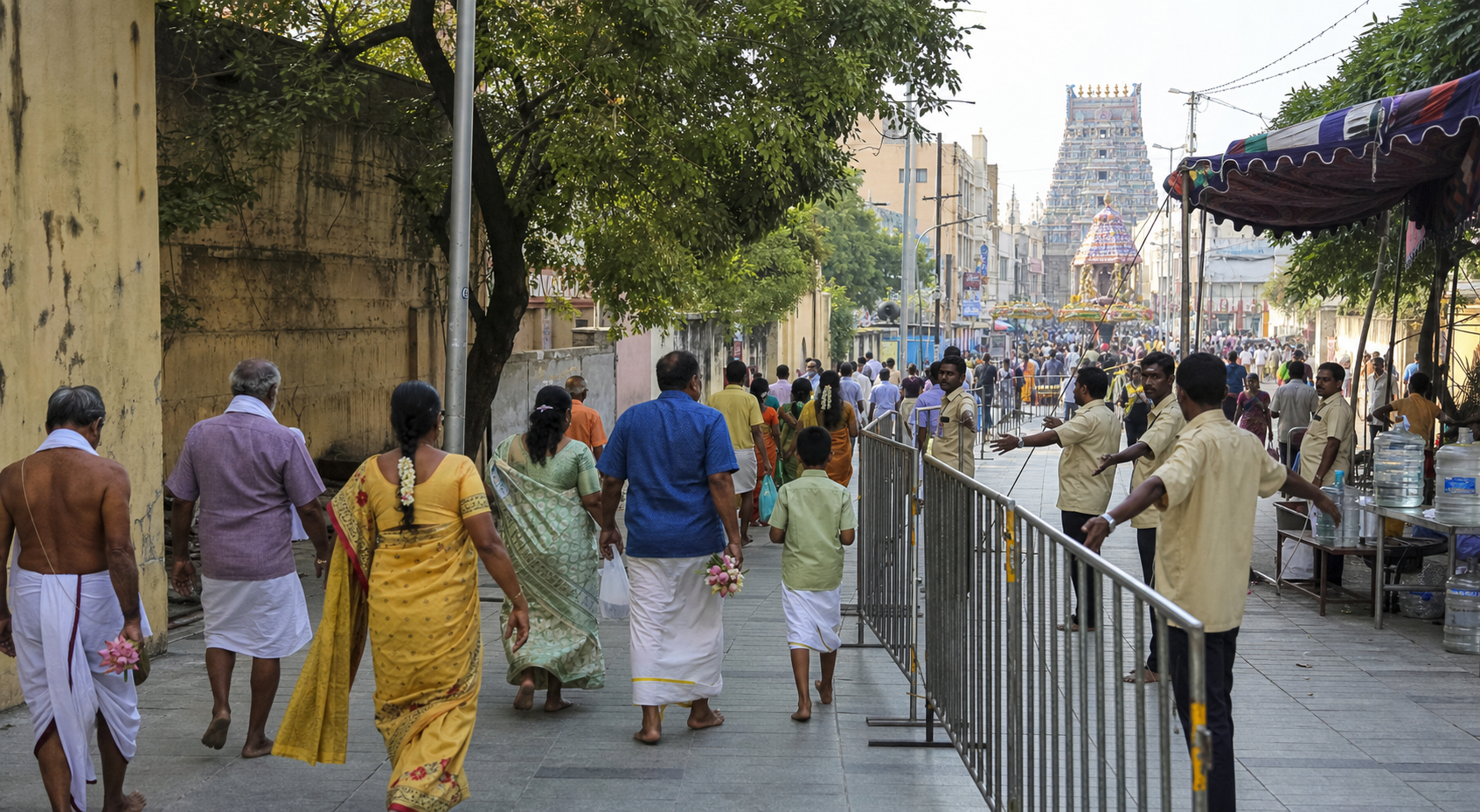Devotees follow managed pedestrian lanes toward a crowded Mylapore temple procession while volunteers guide the route.