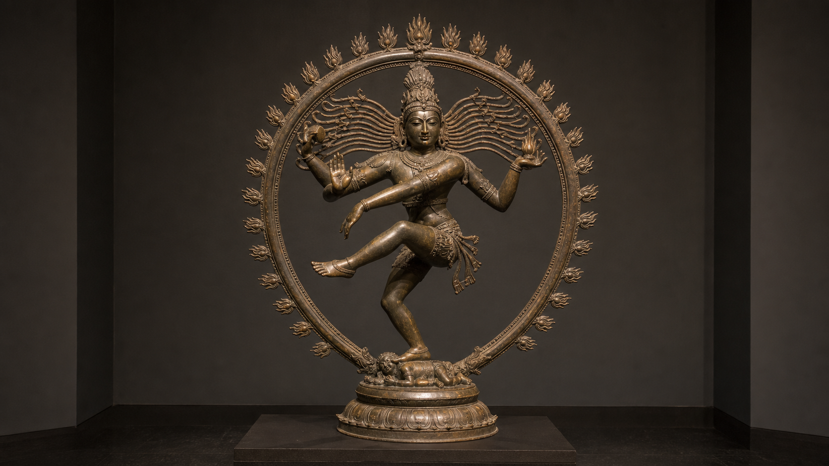 Bronze sculpture of dancing Shiva with four arms, a drum, a flame, an open palm, a lifted foot, and a circular aureole of flames.