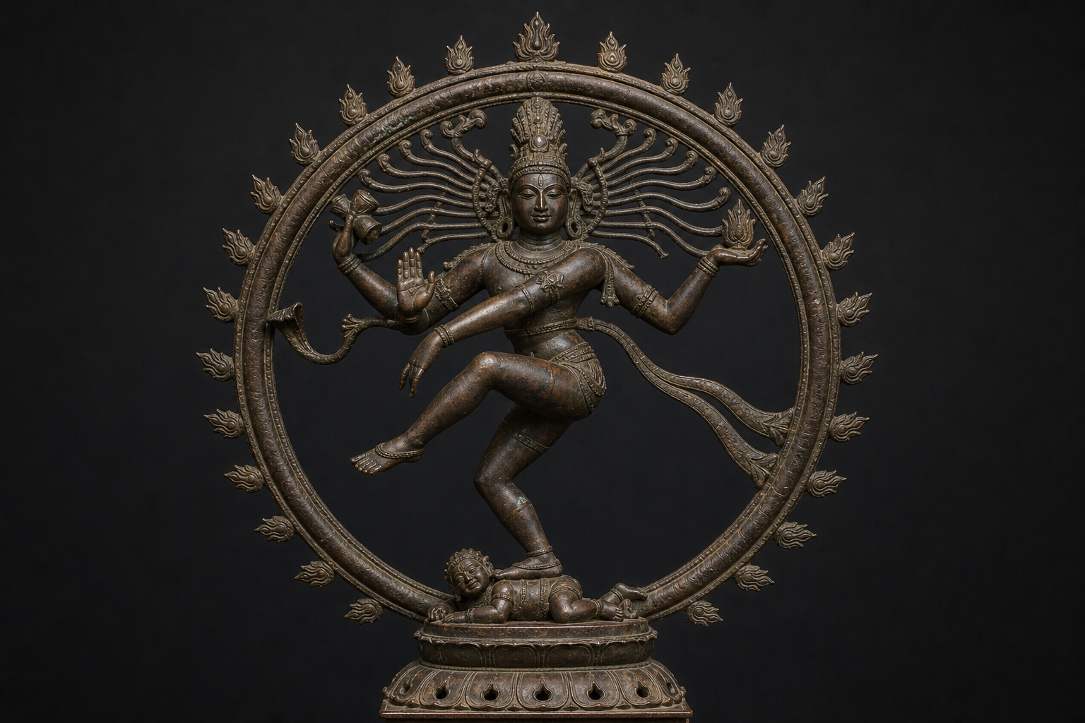 Front view of a bronze Nataraja showing the flame circle, drum and flame attributes, protective hand gesture, crossed lower arm, raised foot, and dwarf beneath the standing foot.