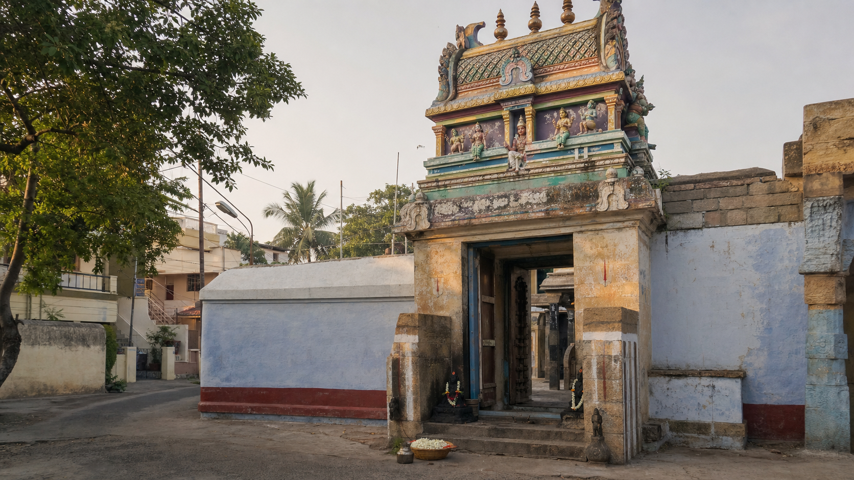 The entrance and Dravidian gateway of Thirukozhi Nachiyar Koil in the Uraiyur neighborhood of Tiruchirappalli at sunrise.