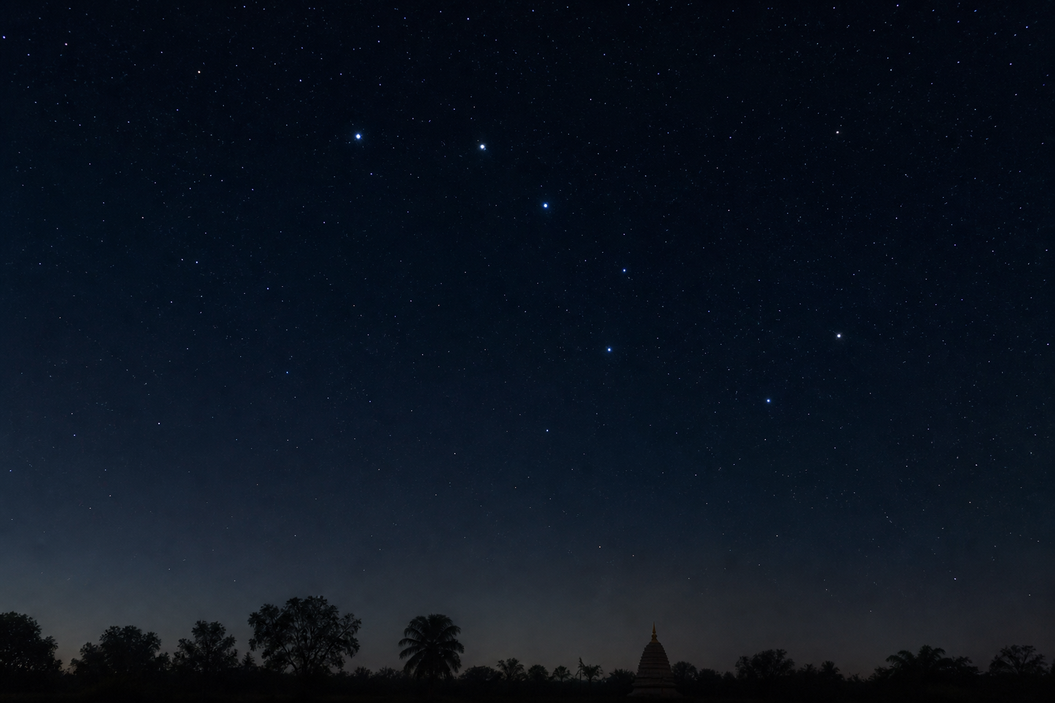 Ursa Major appears above a dark rural horizon, with a bright star and its faint nearby companion visible in the handle.
