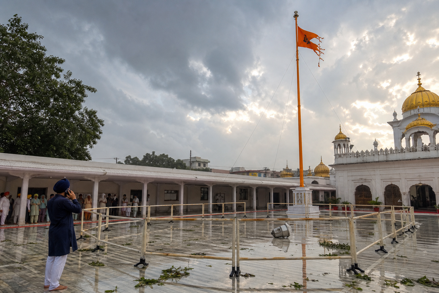 A sevadar keeps people behind a safety barrier while assessing storm damage around a Nishan Sahib pole from a distance.