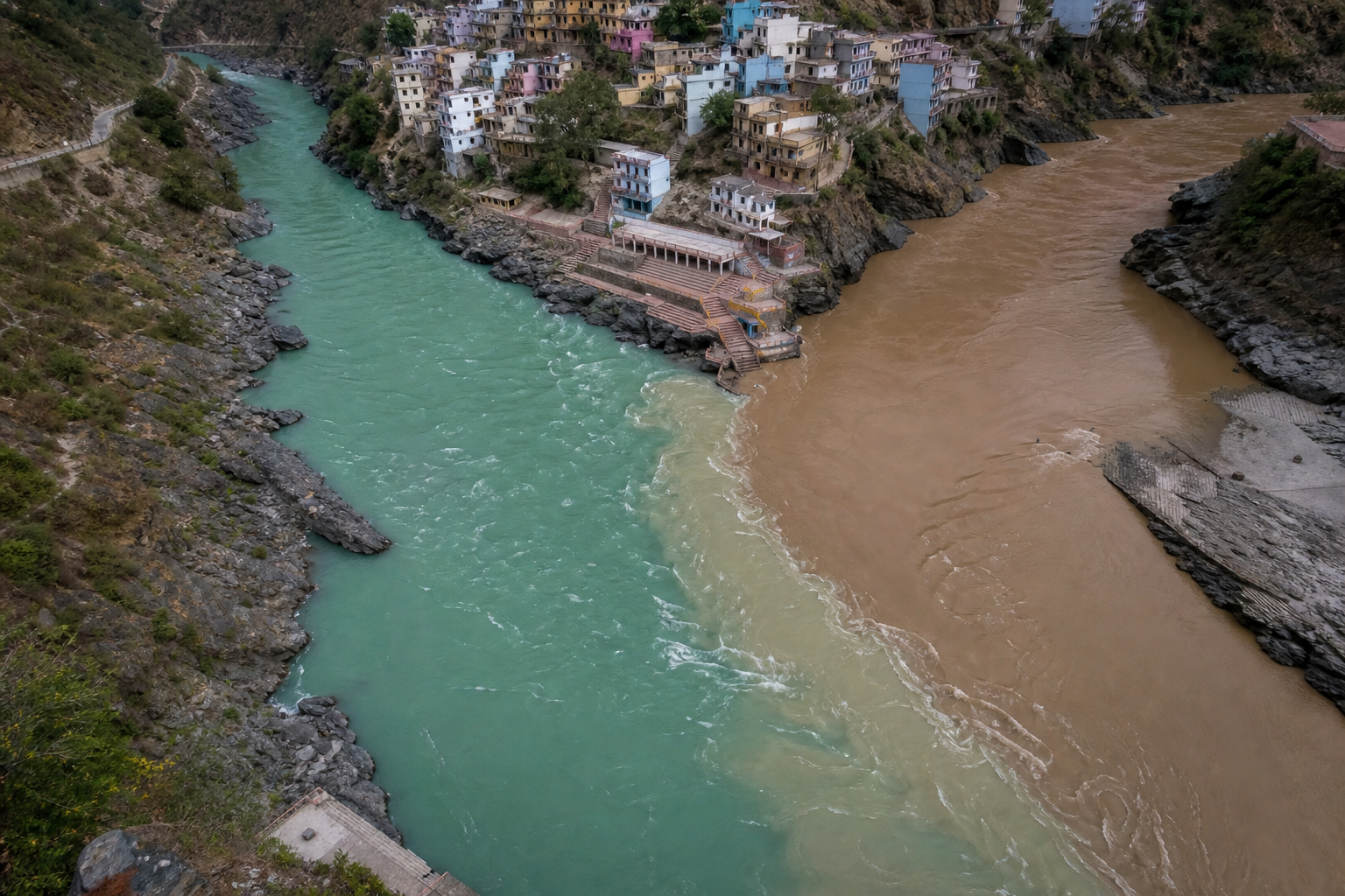 Distinctly colored Bhagirathi and Alaknanda currents joining and gradually blending into one downstream channel at Devprayag.