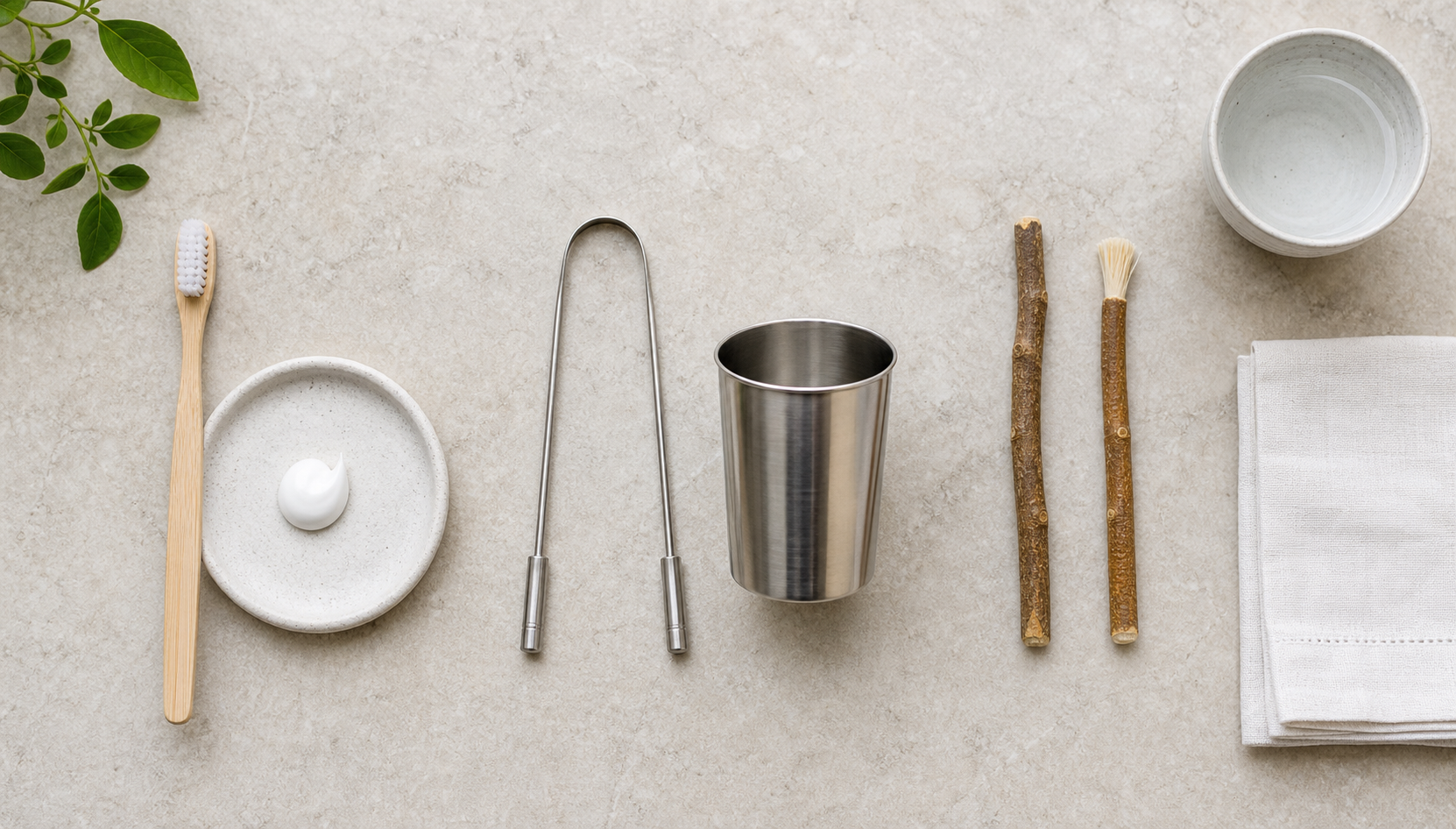 A toothbrush and toothpaste, tongue cleaner and rinsing cup, and fresh fibrous chewing twigs are arranged in separate groups.