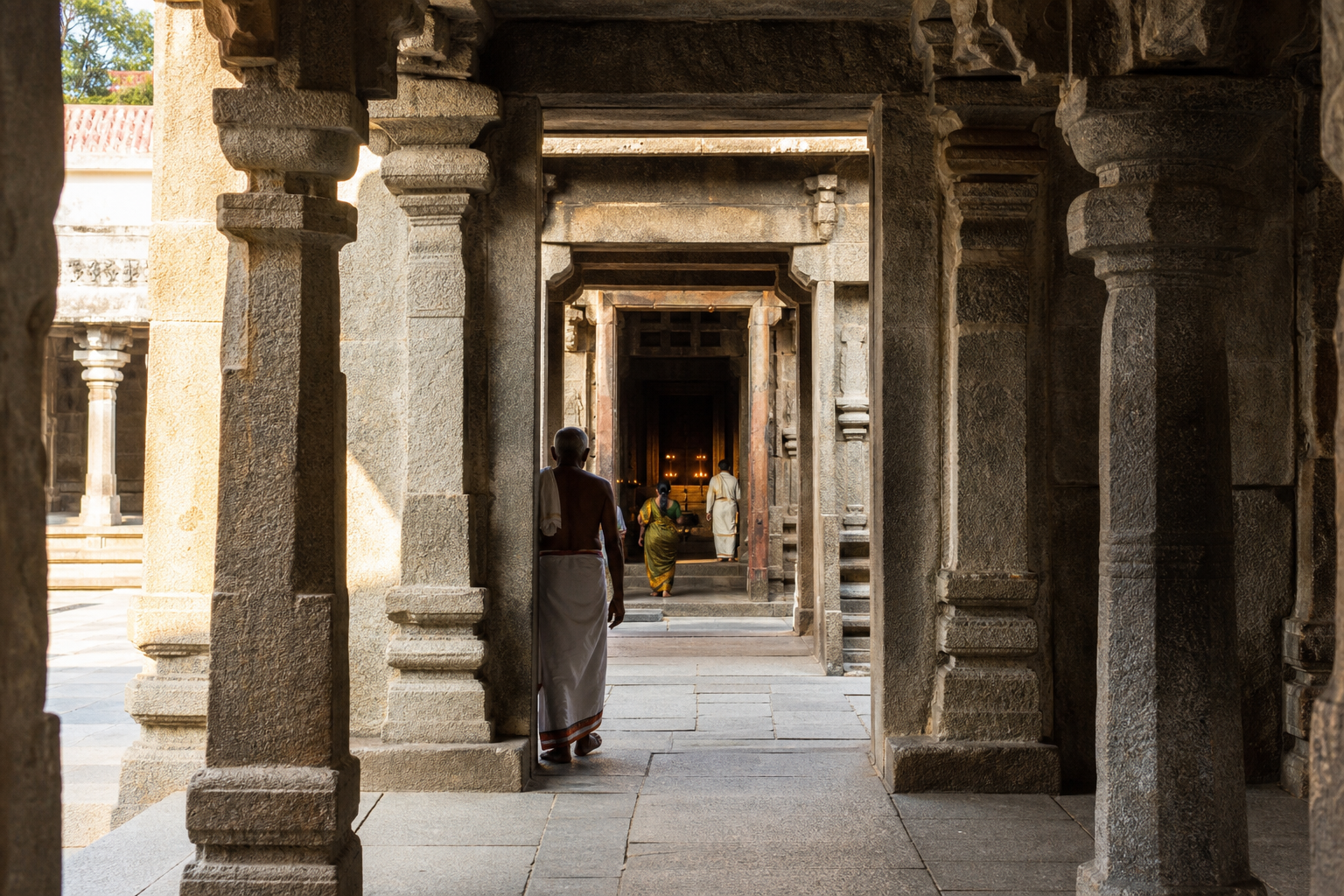 Successive stone thresholds, pillared halls, and enclosure passages leading inward through a South Indian temple.